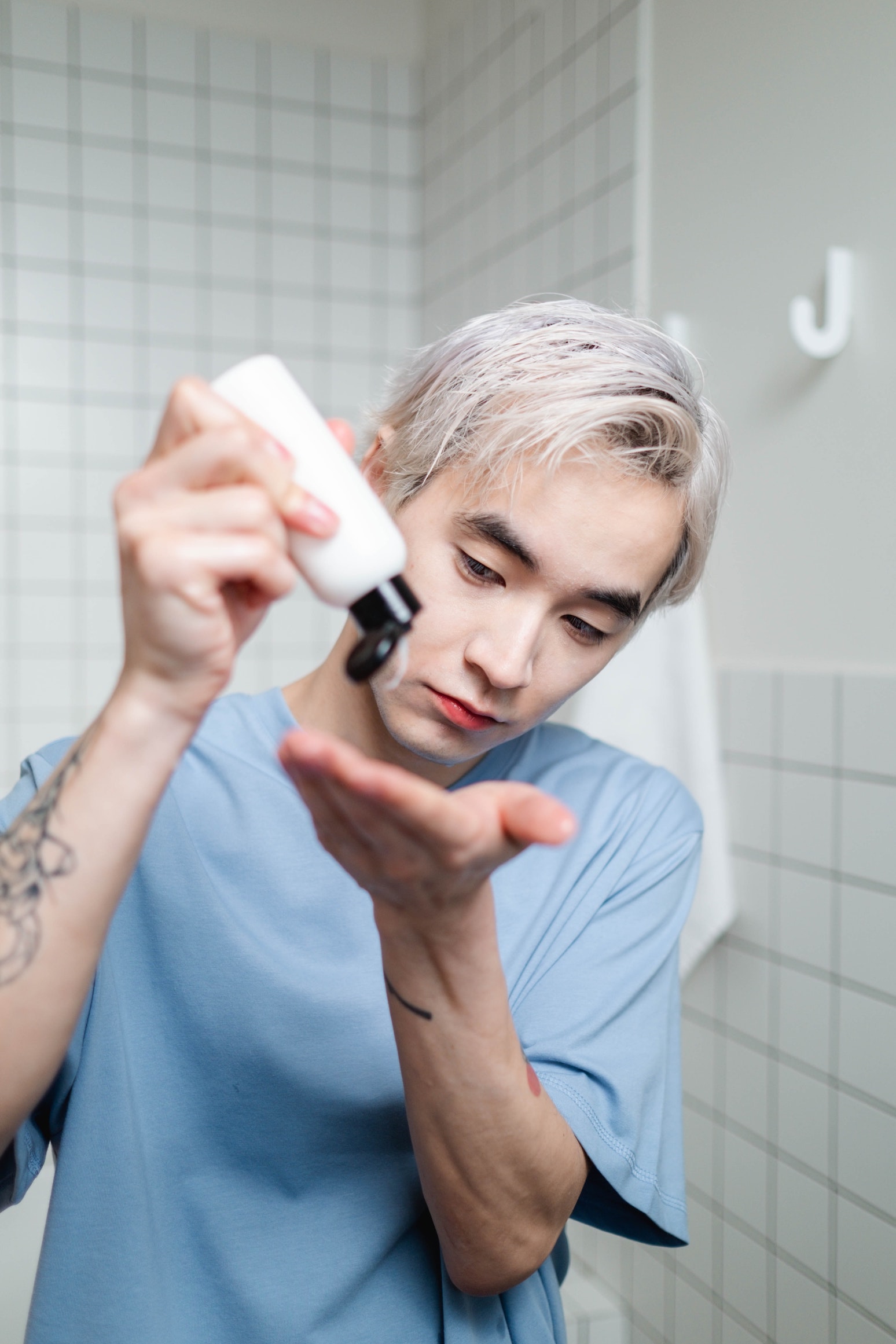 A man squeezing the cleanser onto his hand