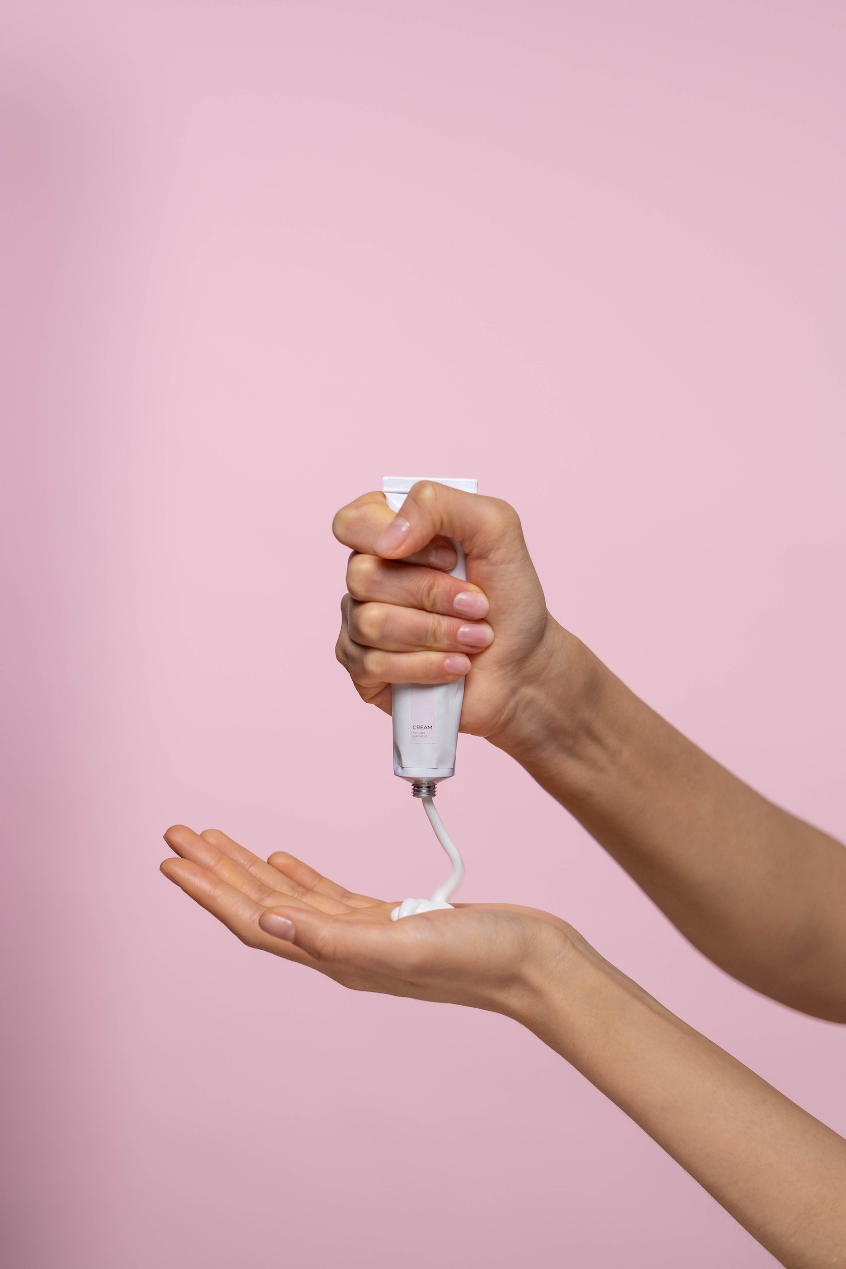 cream being squeezed out onto a woman's hand