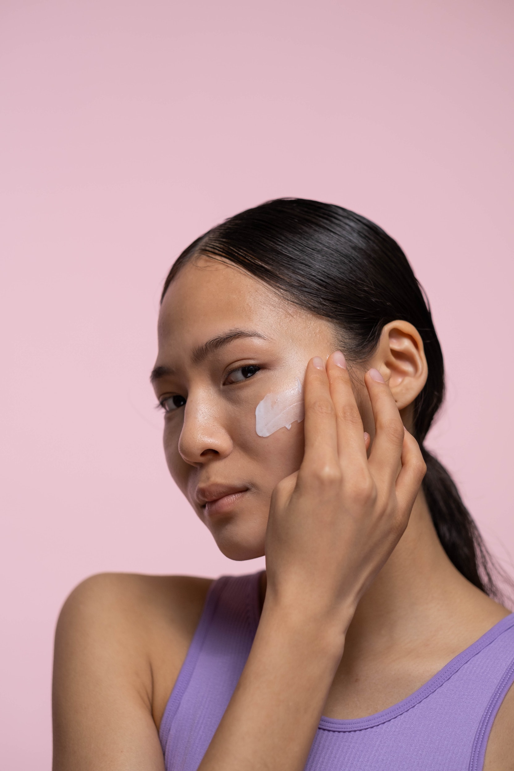 Woman's face with a visible layer of cream on the cheek