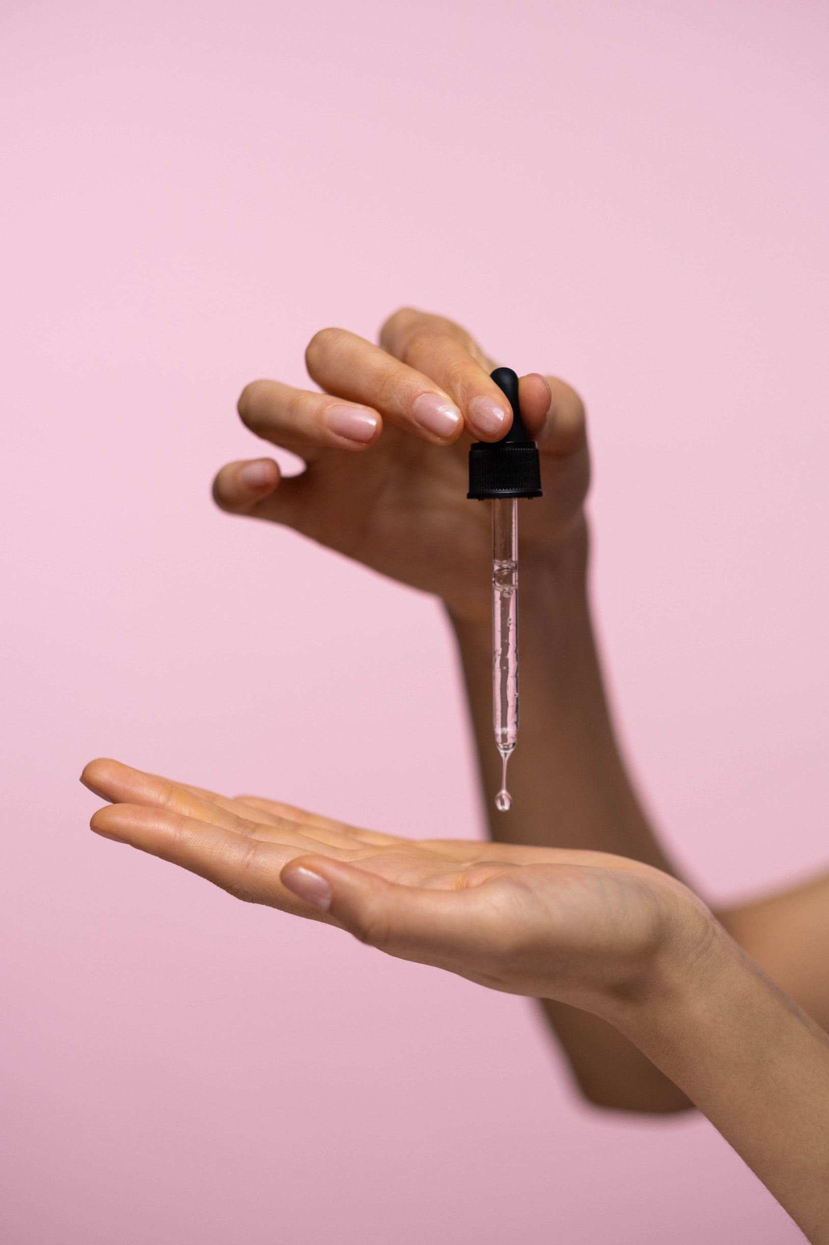 Oil pipette dripping onto a woman's hand